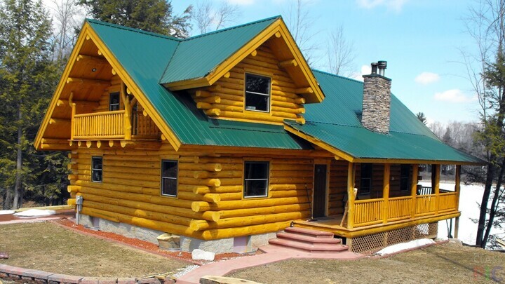 Жёлтый бревенчатый дом с зелёной крышей 